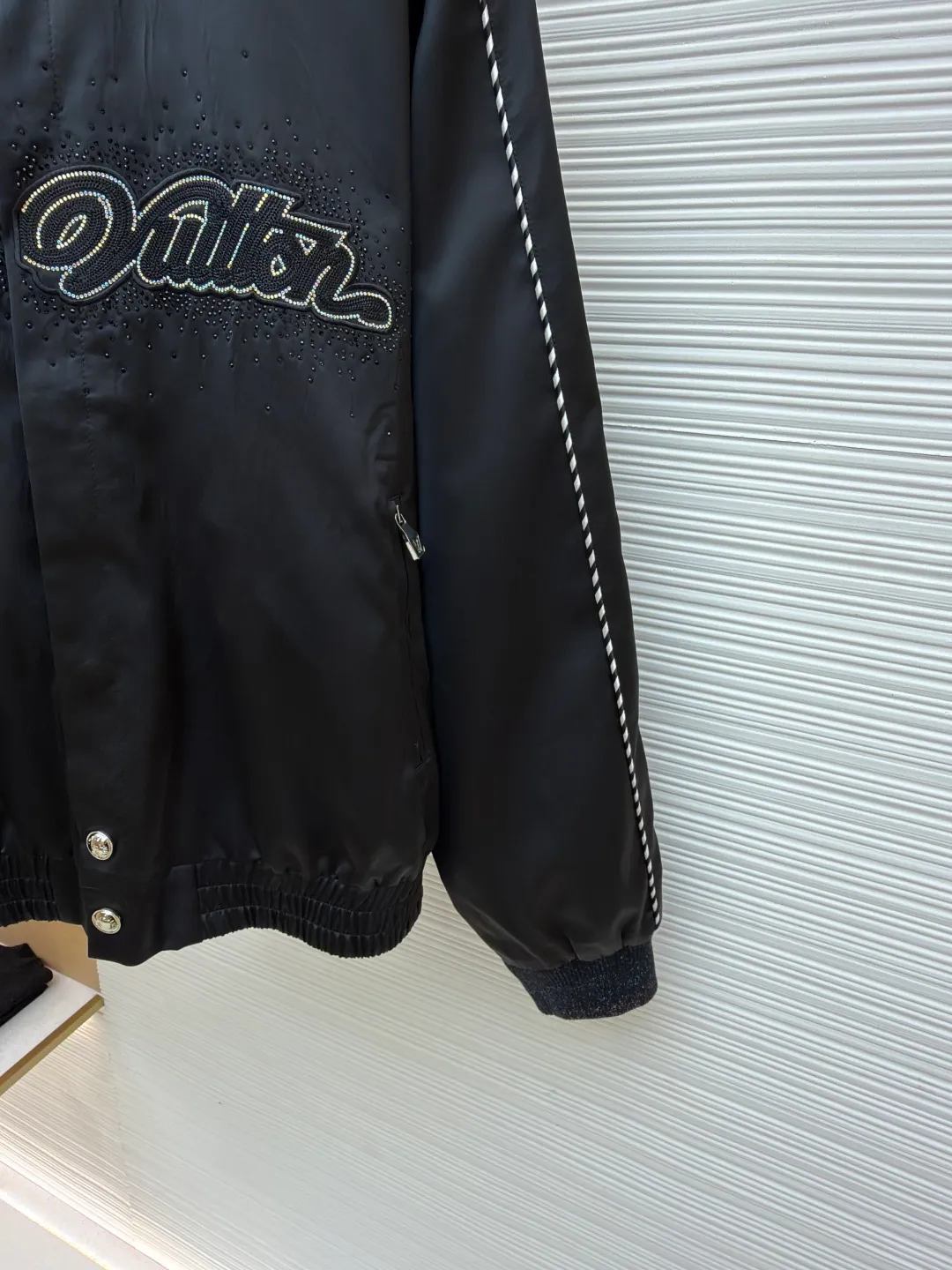 LOUIS VUITTON chest embroidered rhinestone jacket ●Original version: Purchased and developed at 22889 ●Item number: 1681600-B70 ●Material: 100% cotton ●Technology: rhinestone production ●Color: black ●Version: Fitted version ●Weight: about 740 grams ●Size: 46-48-50-52 ●Description: This Louis Vuitton jacket is made of high-quality black satin material, with a delicate texture and rich luster. The craftsmanship incorporates a variety of advanced production technologies: the eye-catching brand logo on the chest is combined with three-dimensional embroidery and hot-drilling technology. The stitching is precise and layered, highlighting the brand's unique recognition; the black and white braided belt decoration on the shoulders and sides not only increases the visual hierarchy, but also enhances the overall sense of fashion and sophistication. The neckline and cuffs are neatly cut and have smooth lines, showing a simple yet high-end style. The zipper and metal buckle have exquisite details and outstanding texture. Manual tile measurement, the error of 1-3CM is within the normal range, which is also the uniqueness of manual craftsmanship. Whether it is worn for daily wear or paired with a jacket, it can easily show fashionable taste and luxurious temperament. The overall wiring is straight and delicate, the fabric is comfortable and soft, and the color is consistent without color difference. It can be matched with the same style to create a fashionable look and control various occasions. Customized accessories, complete with three standards, same style for men and women!